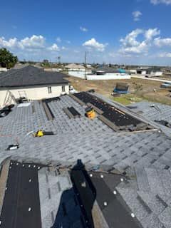 A roof is being installed on a house with a blue sky in the background.