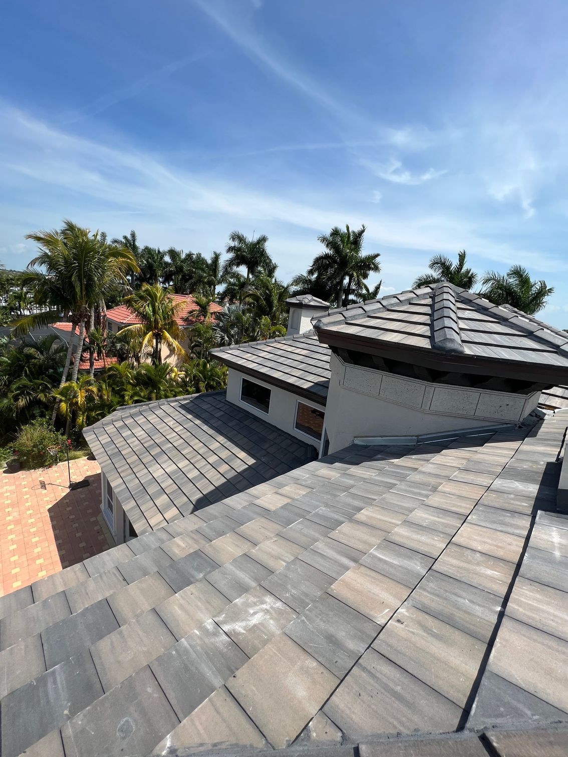 The roof of a house with a tiled roof and a chimney.