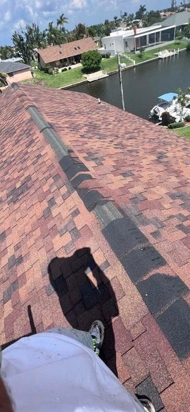 A person is working on the roof of a house.