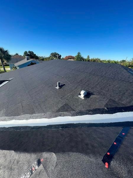A roof with a fan on it and a blue sky in the background.