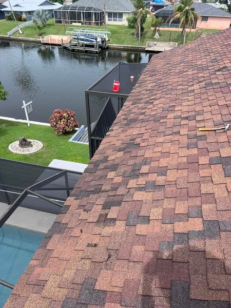 The roof of a house with a view of a body of water.