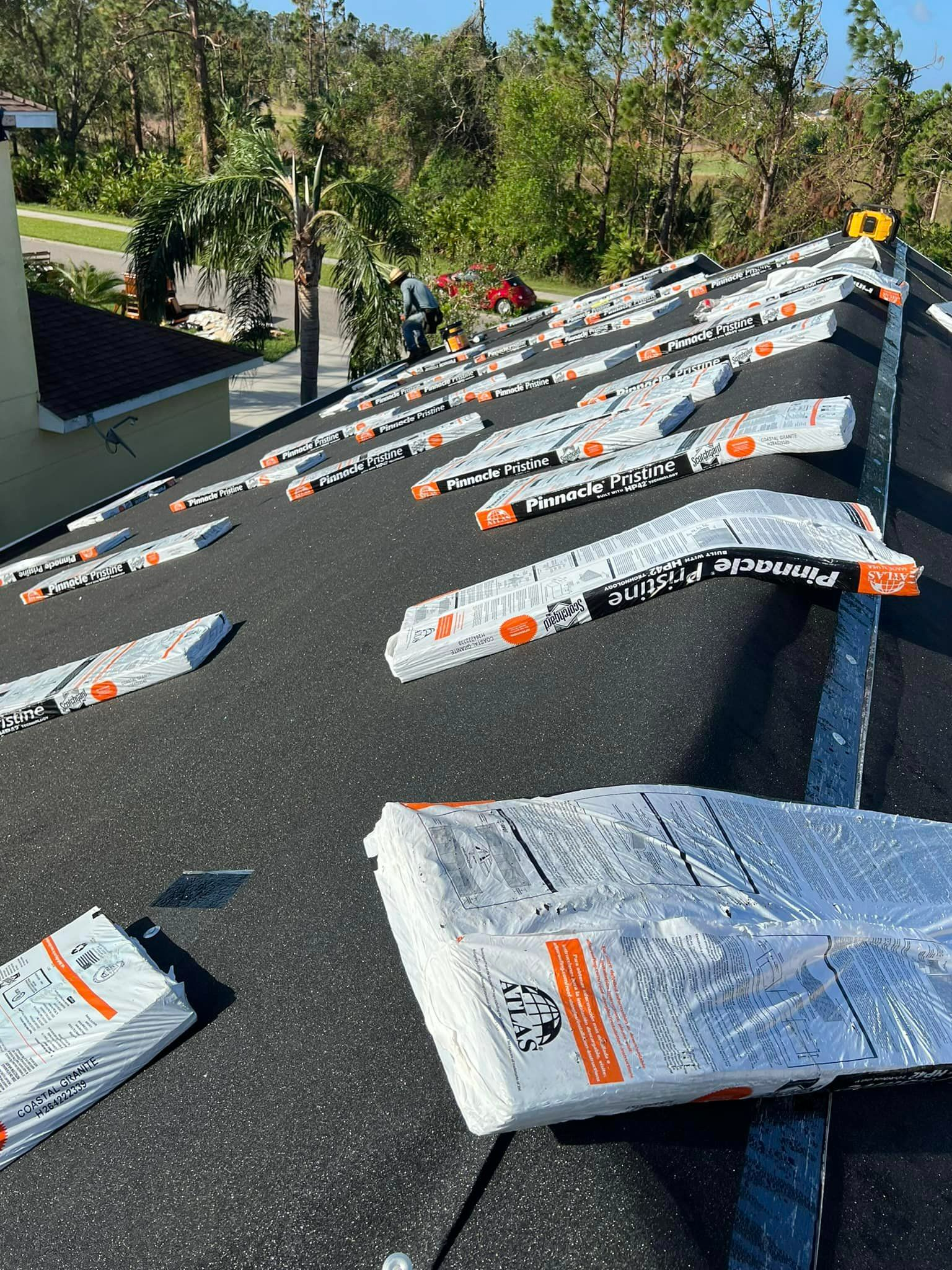 A roof with a lot of bags of shingles on it.