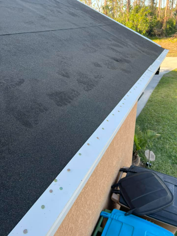 A house with a black roof and a white gutter.