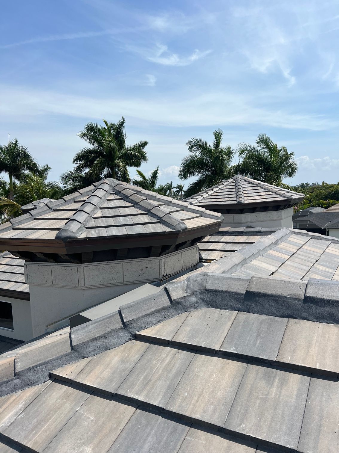 A roof with a lot of tiles on it and a blue sky in the background.