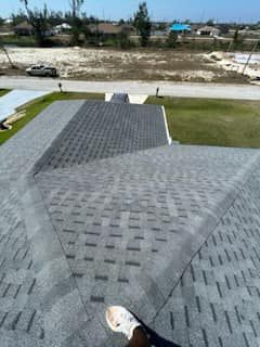 A person is standing on the roof of a house.