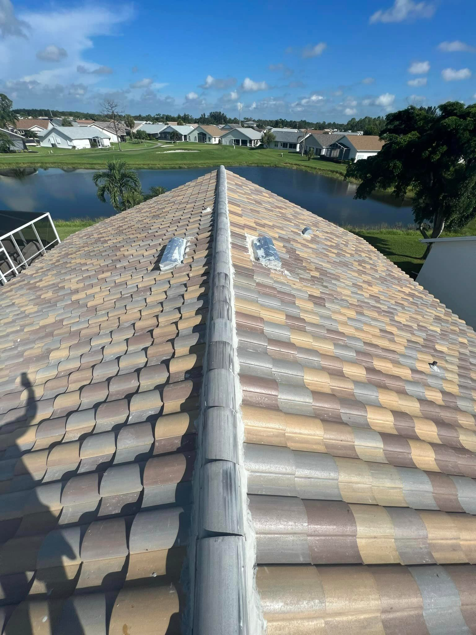A roof with a lot of tiles and a skylight on it.