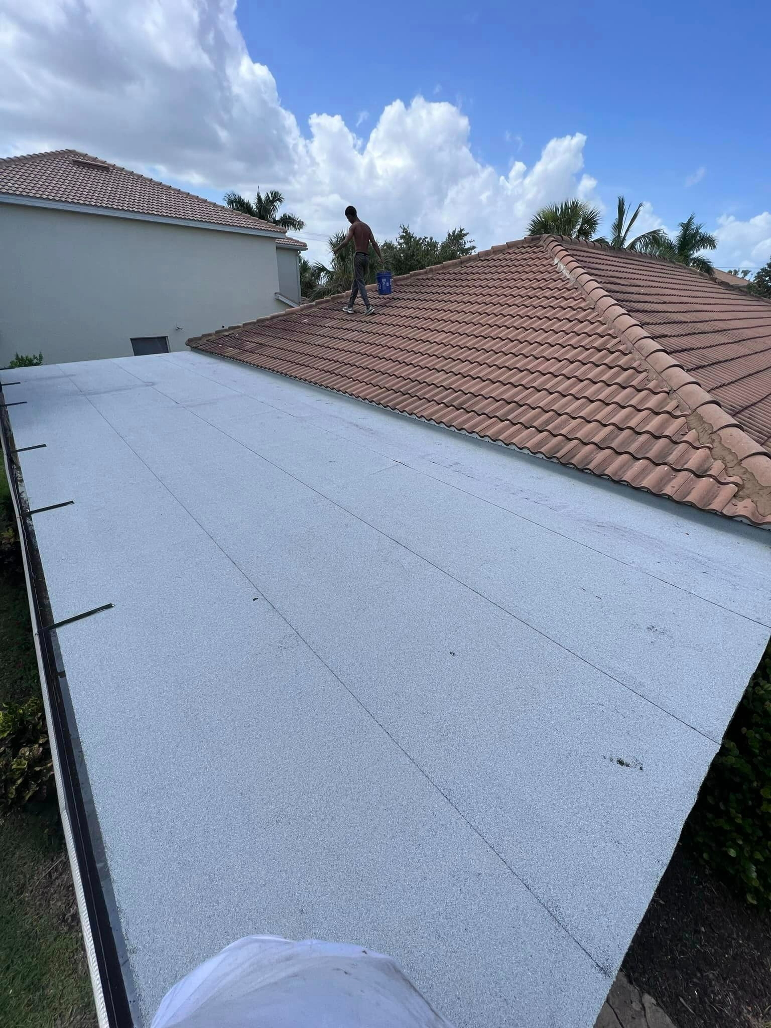 A man is standing on the roof of a house.