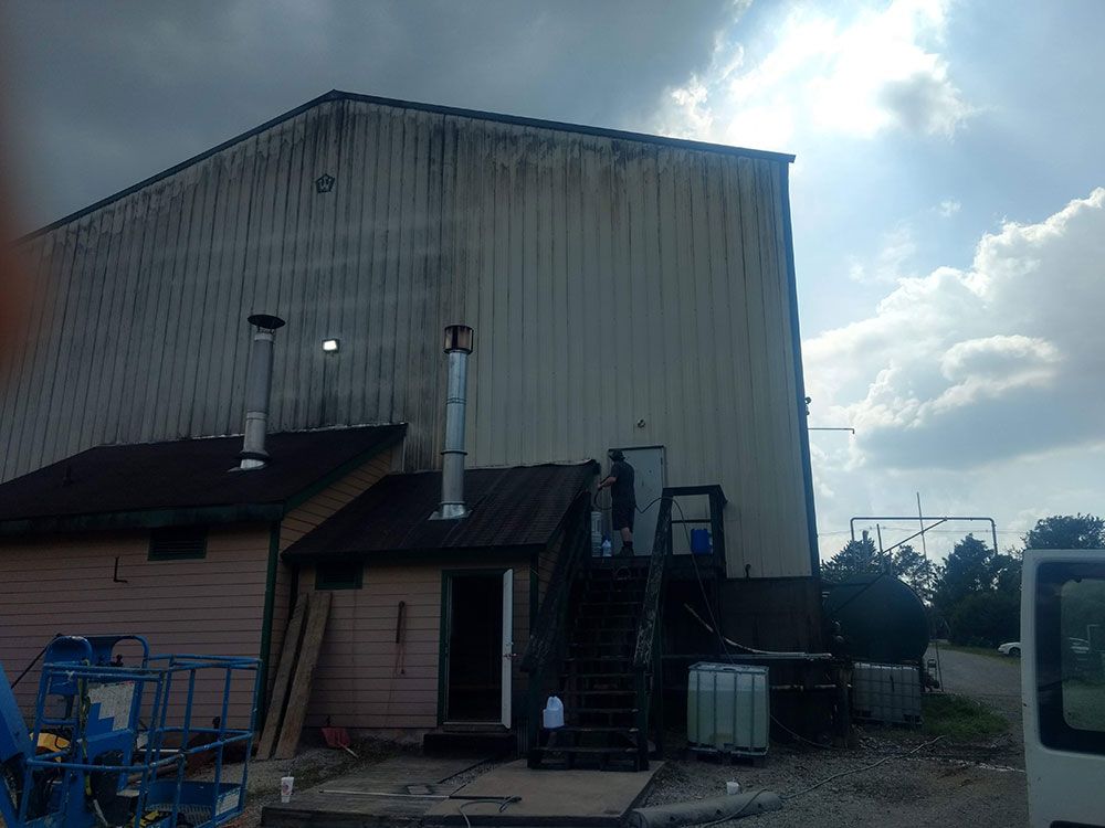 A white van is parked in front of a large building.