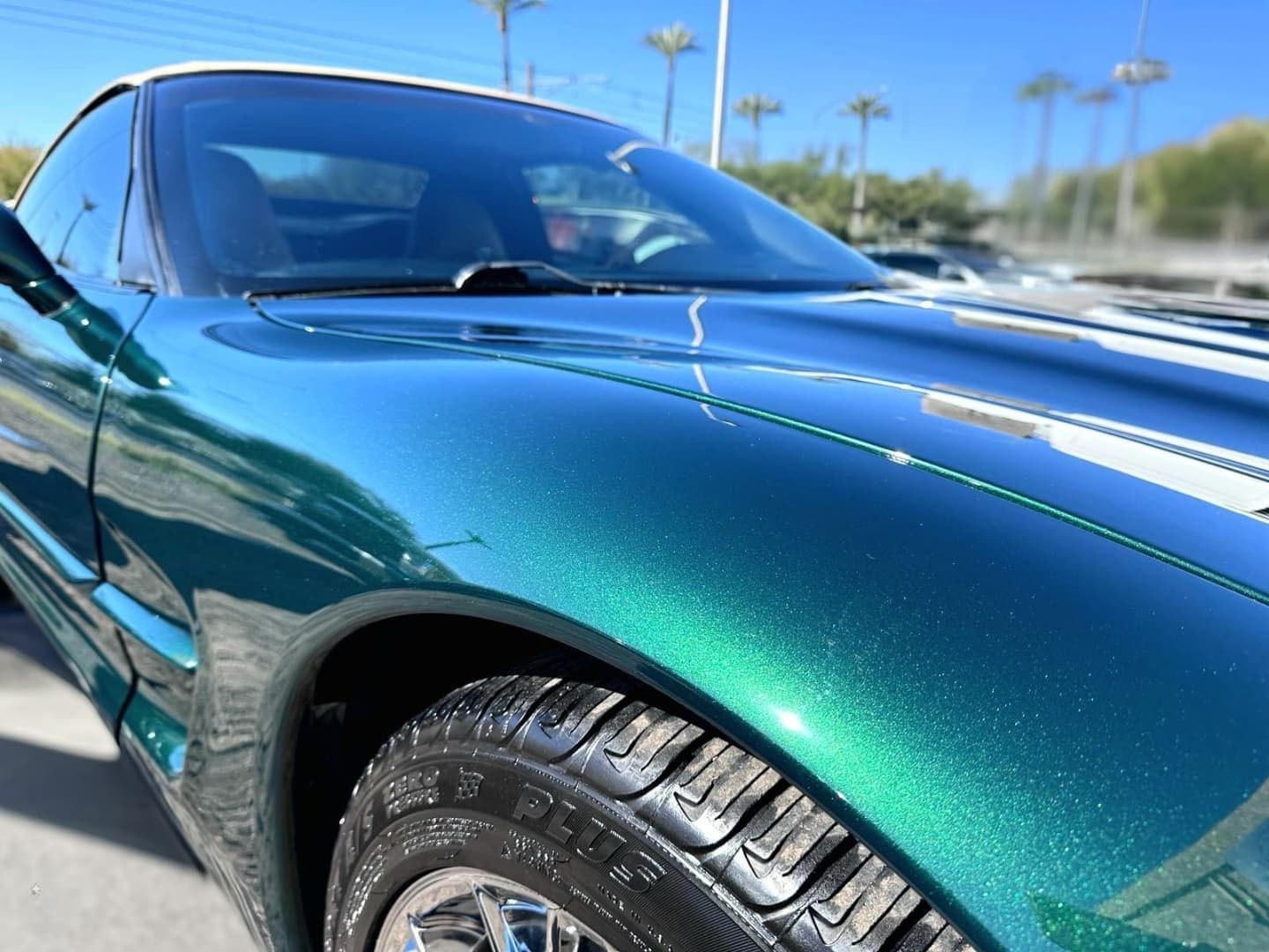 A green sports car is parked on the side of the road.
