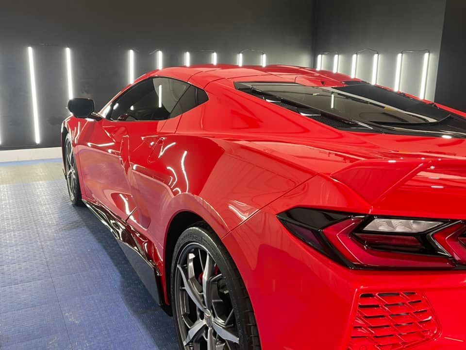 A red sports car is parked in a garage.