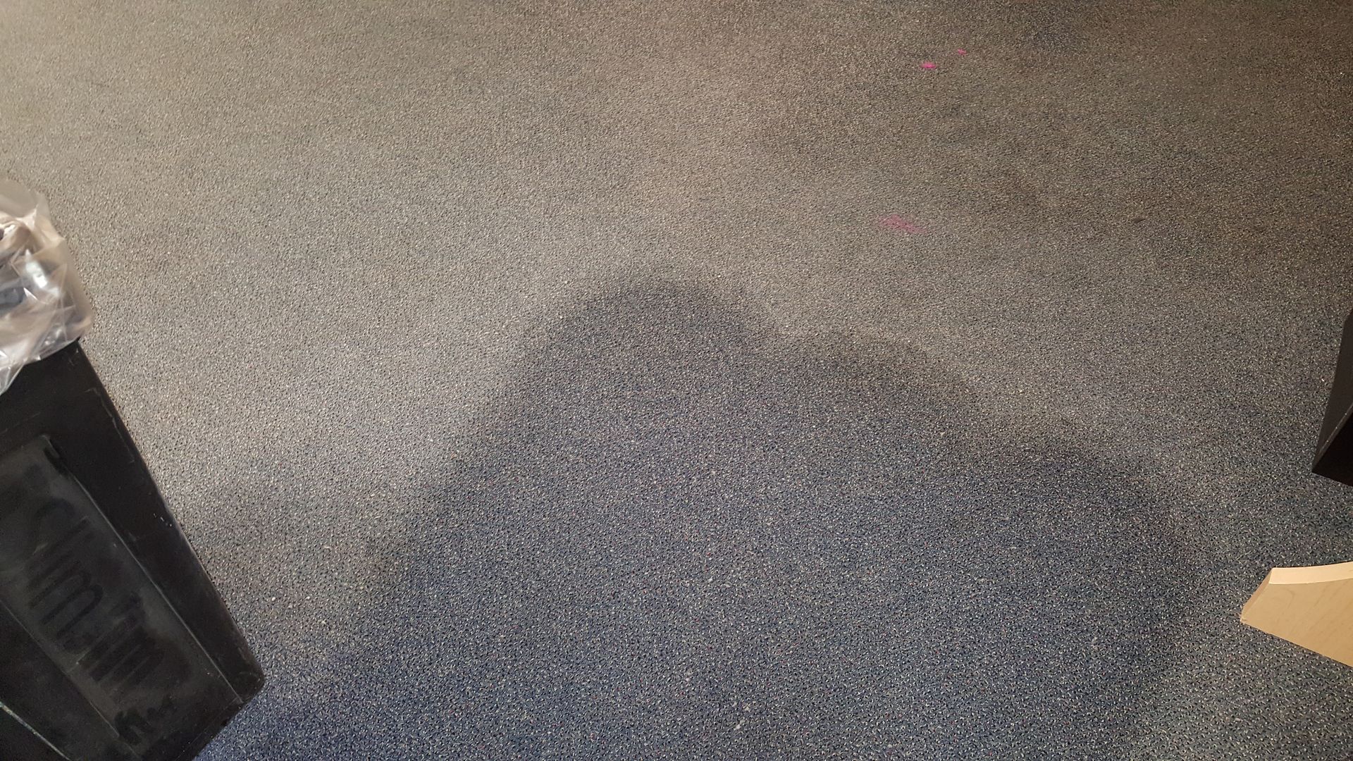 a gray carpeted floor with speakers on it in a room