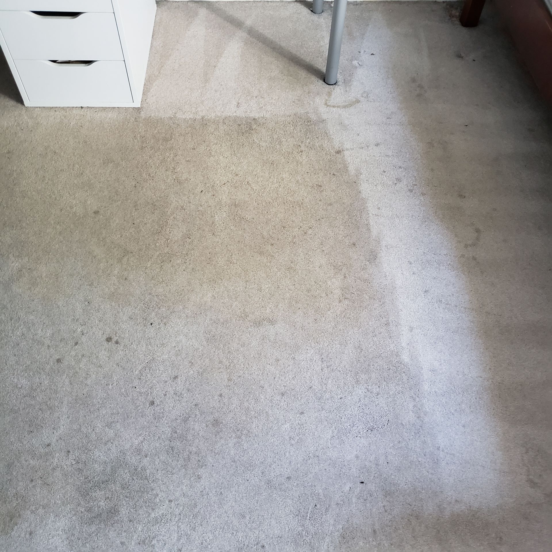 a dirty carpet in a bedroom next to a desk
