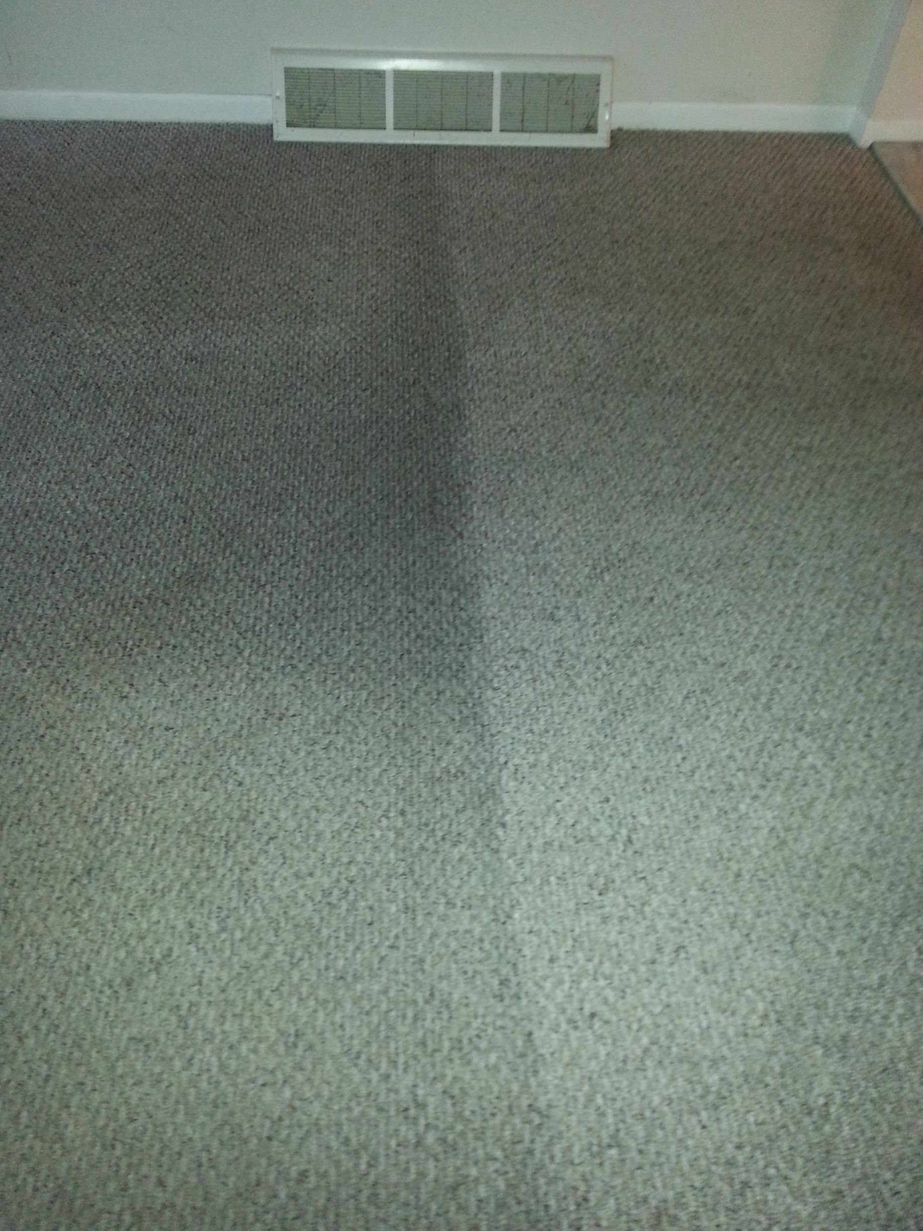 a room with a gray carpet and a white air vent