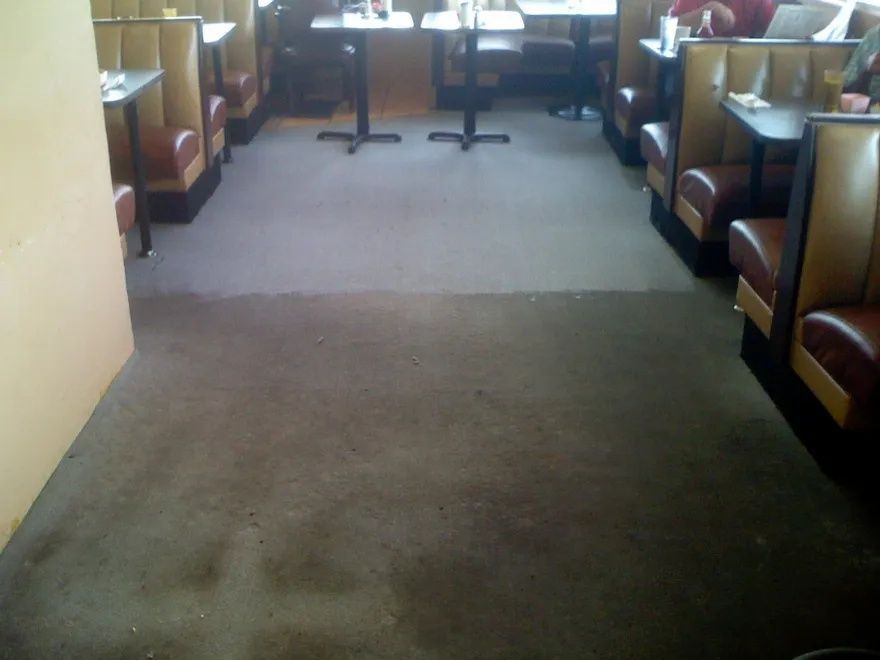 a diner with tables and booths and a dirty floor