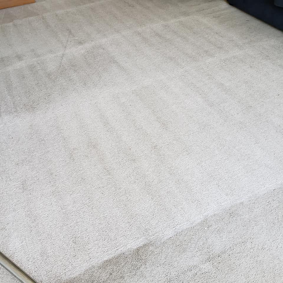 a white carpet is sitting on the floor in a living room next to a couch