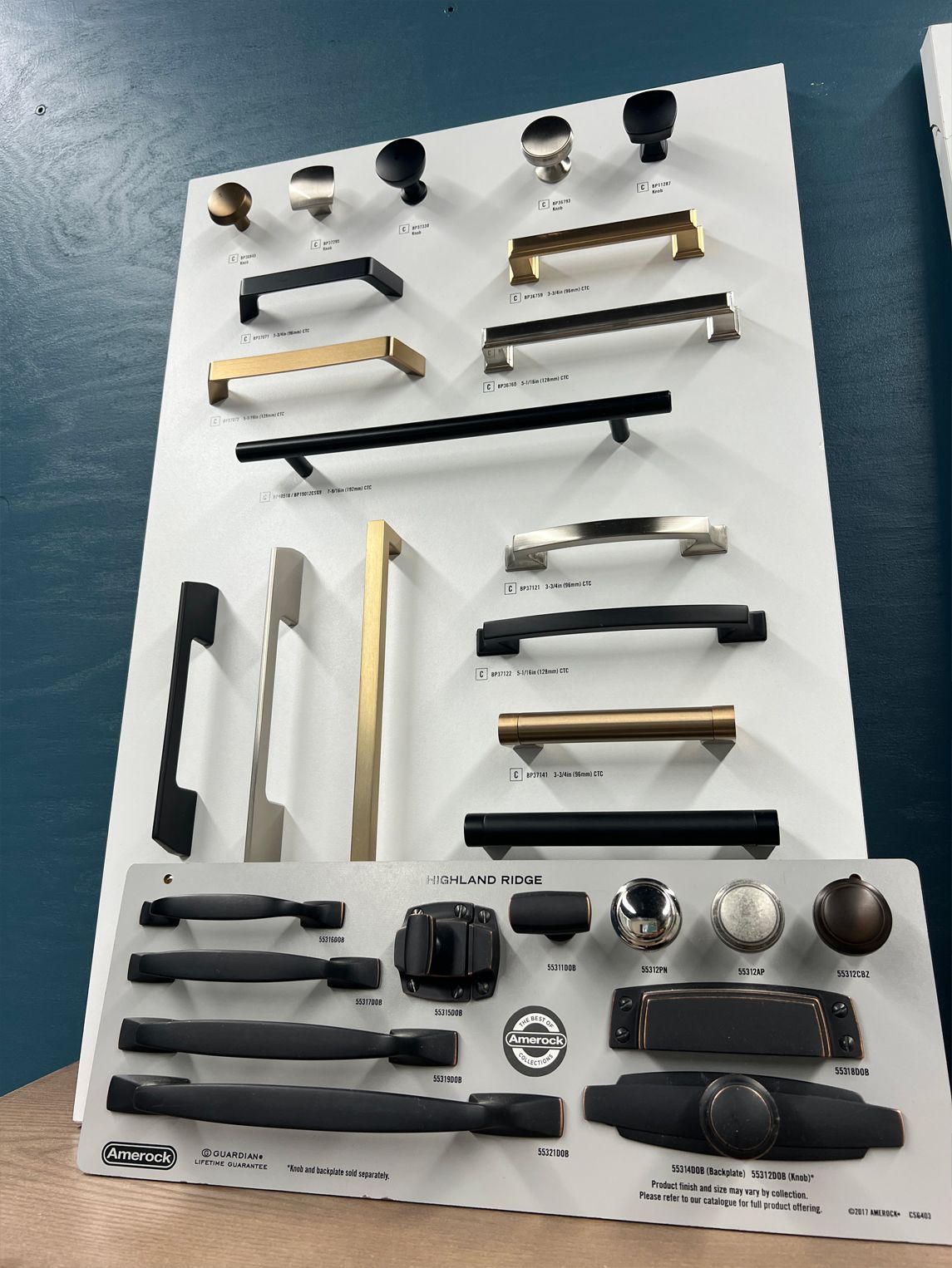 Cabinet hardware display board featuring various knobs and pulls in different styles and finishes.