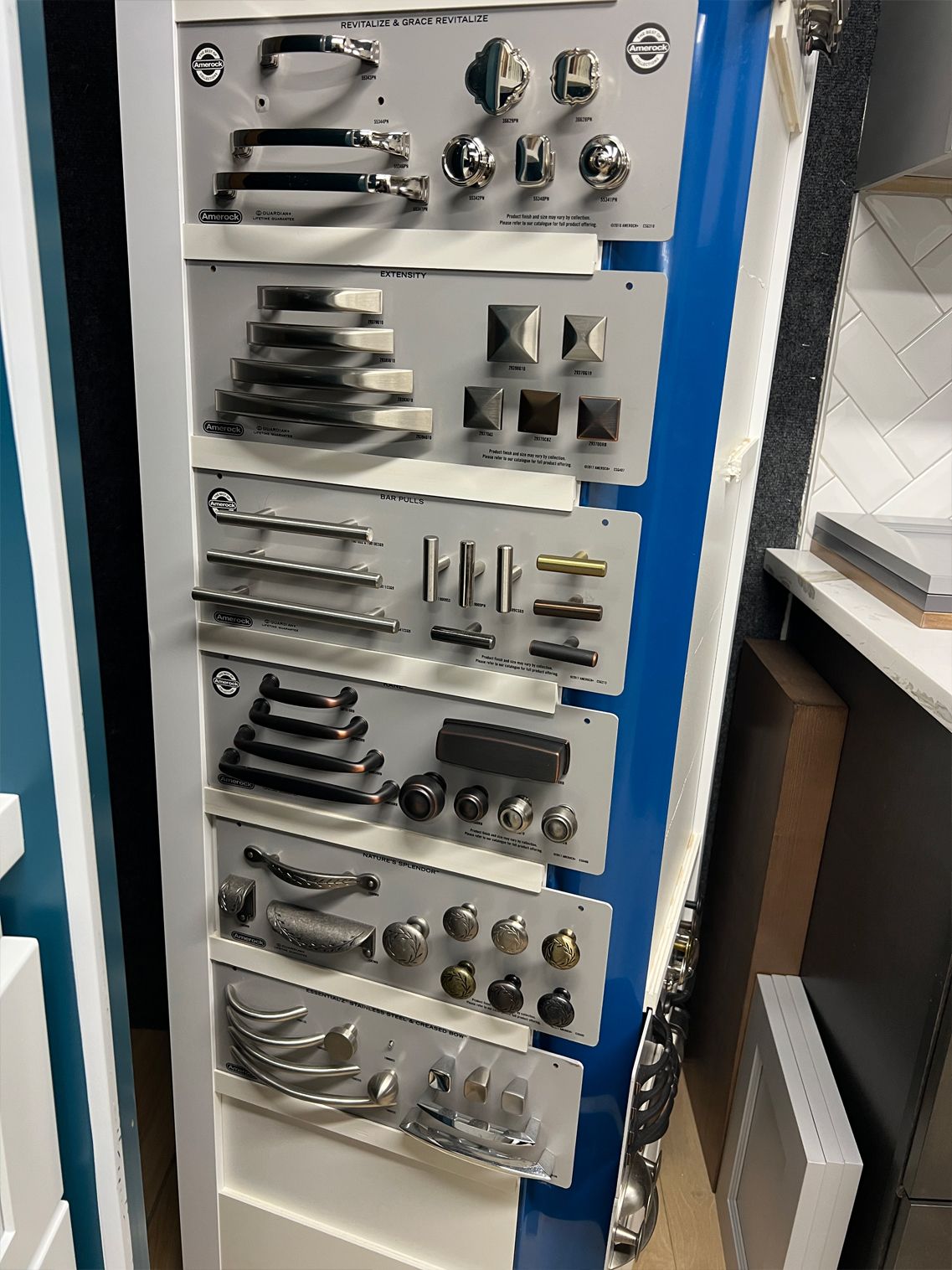 Display of cabinet hardware samples in a store, including handles and knobs in various styles and finishes.