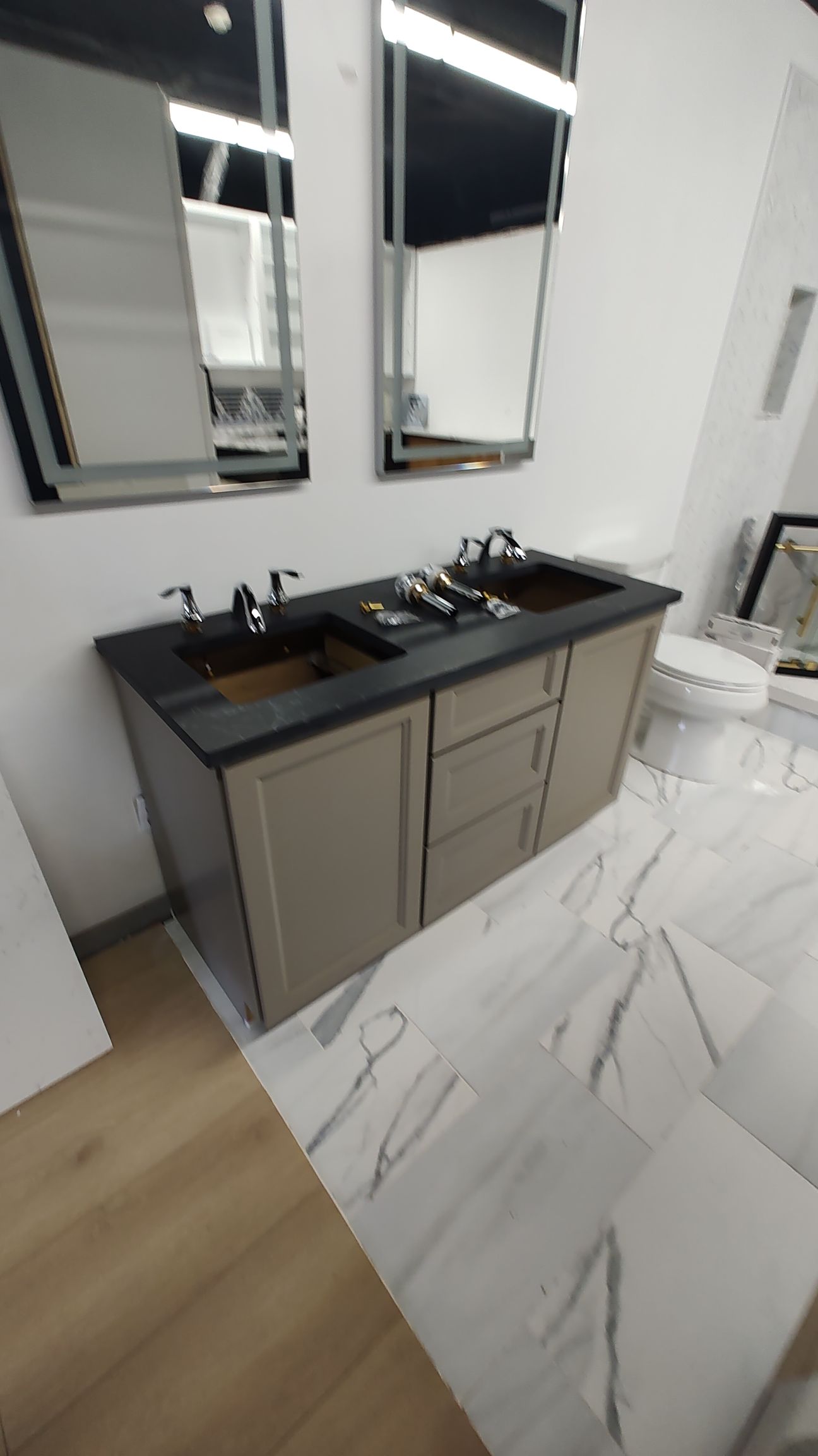 A bathroom with two sinks , two mirrors and a toilet.