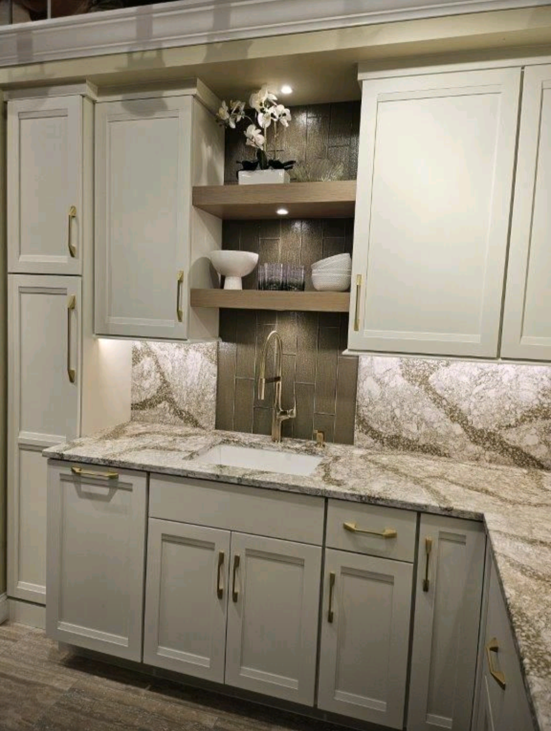 A kitchen with white cabinets, granite countertops, and a sink.