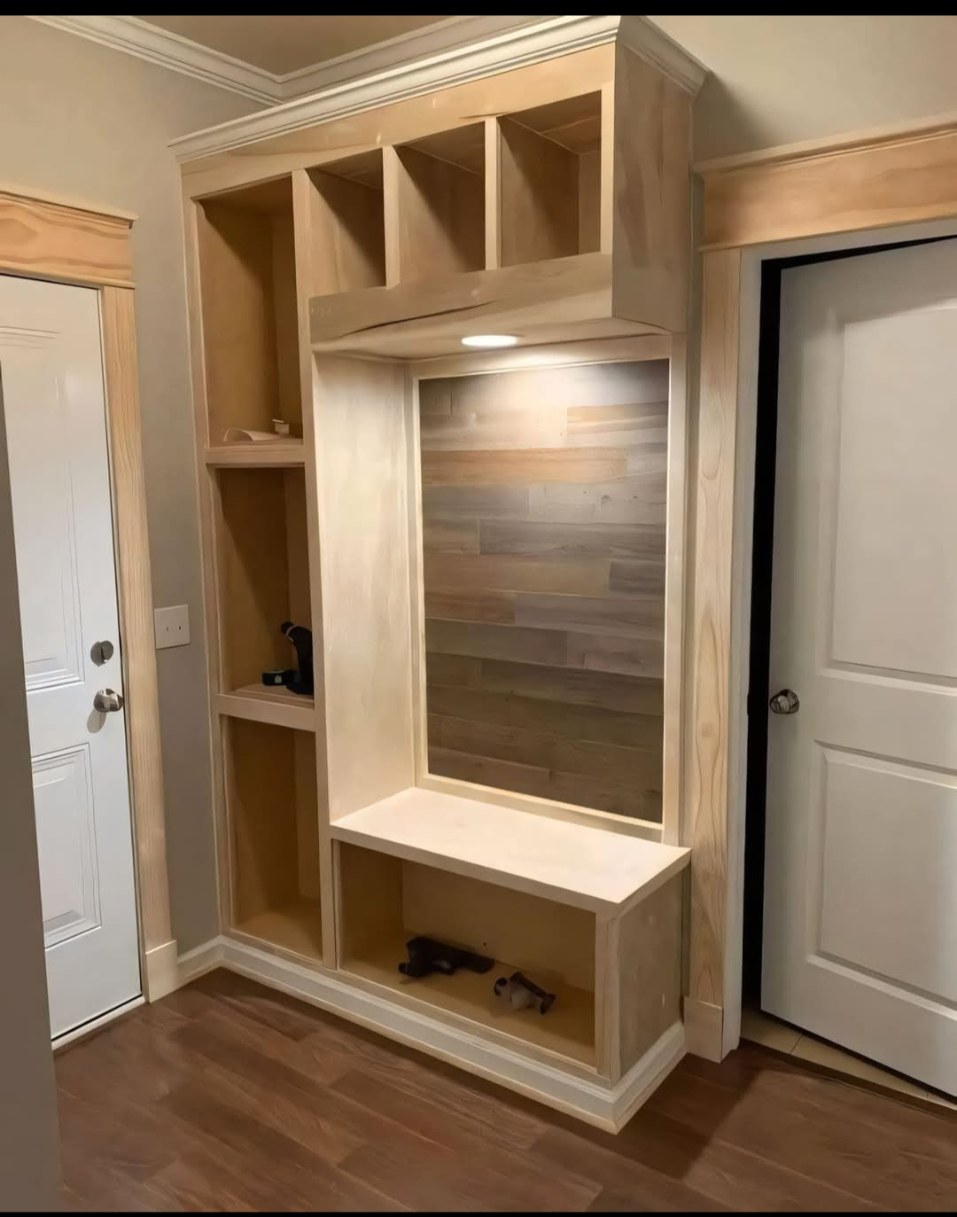 A hallway with a wooden shelf and a white door.