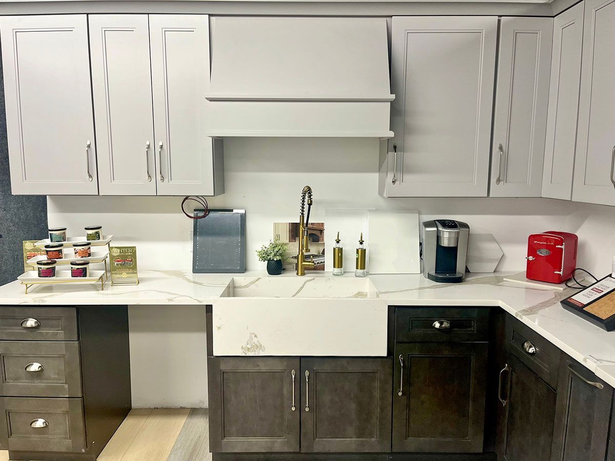 A newly remodeled kitchen with white cabinets and a sink