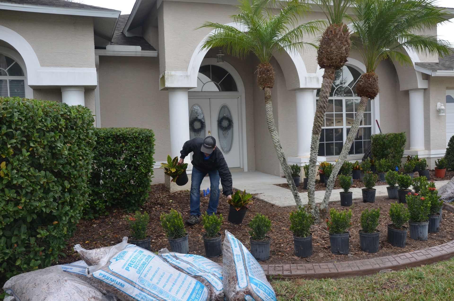 a man is planting plants in front of a house
