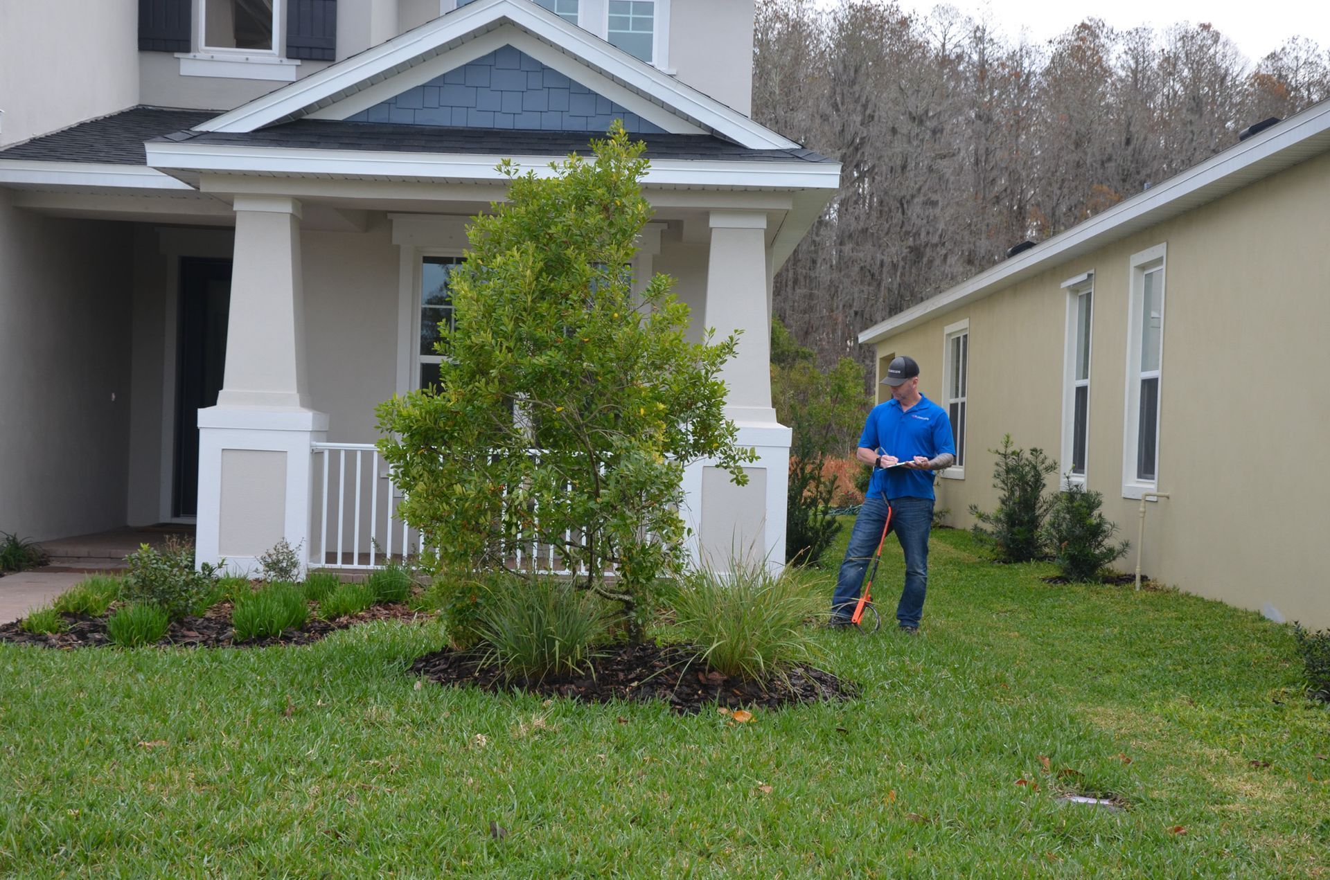 a man is standing in front of a house holding a clipboard