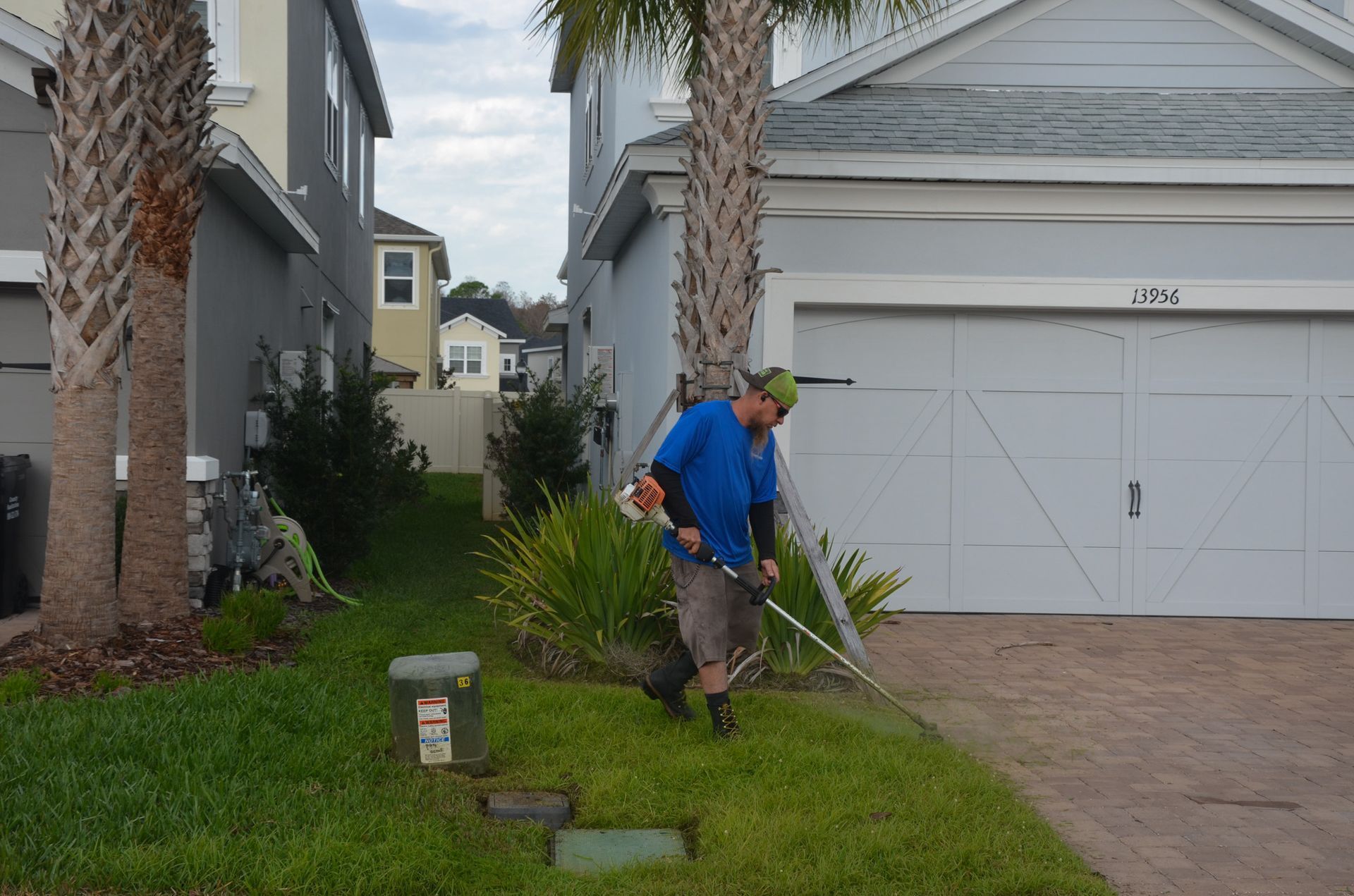 a man is using a lawn mower to cut the grass in front of a house