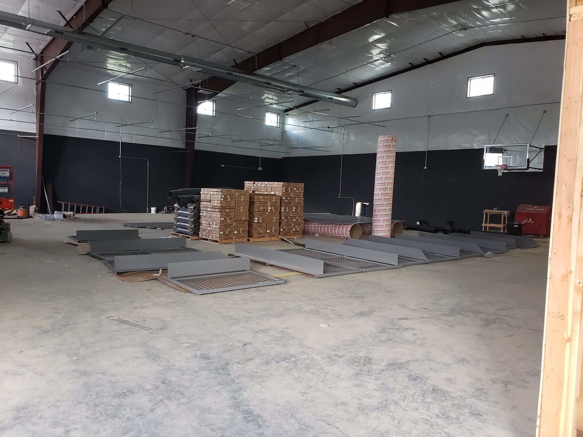 A large empty warehouse with a lot of boxes on the floor.