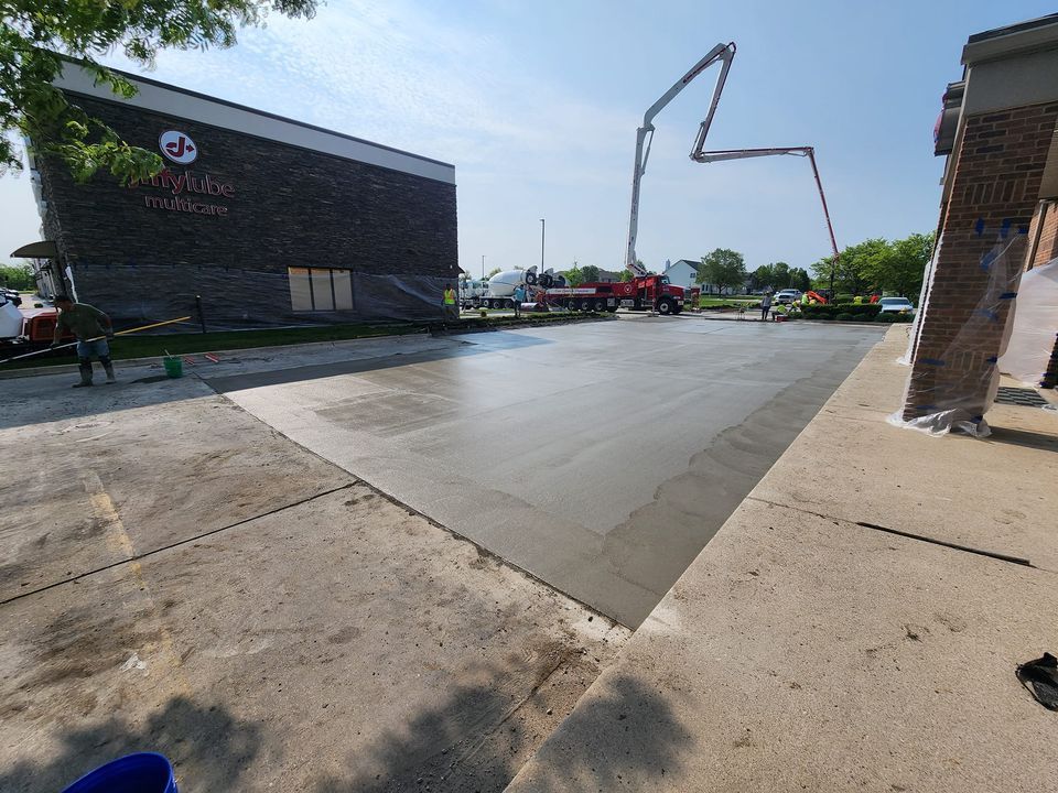 A concrete driveway is being poured in front of a building.