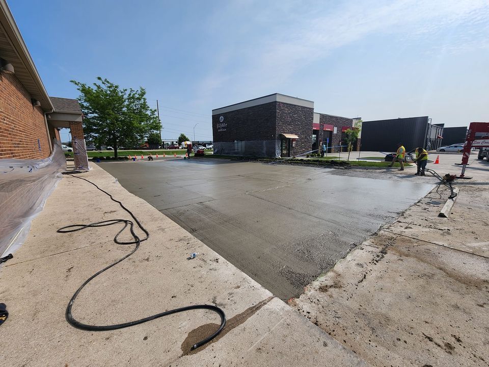 A concrete driveway is being built in front of a building