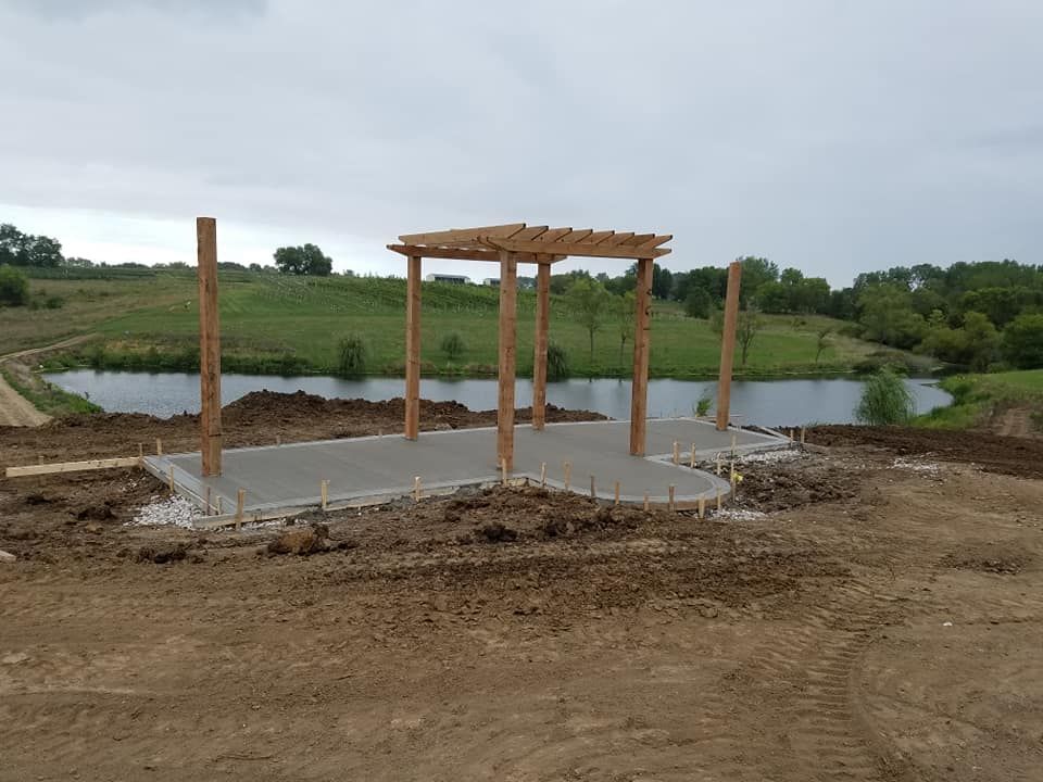 A pergola is being built in the middle of a dirt field