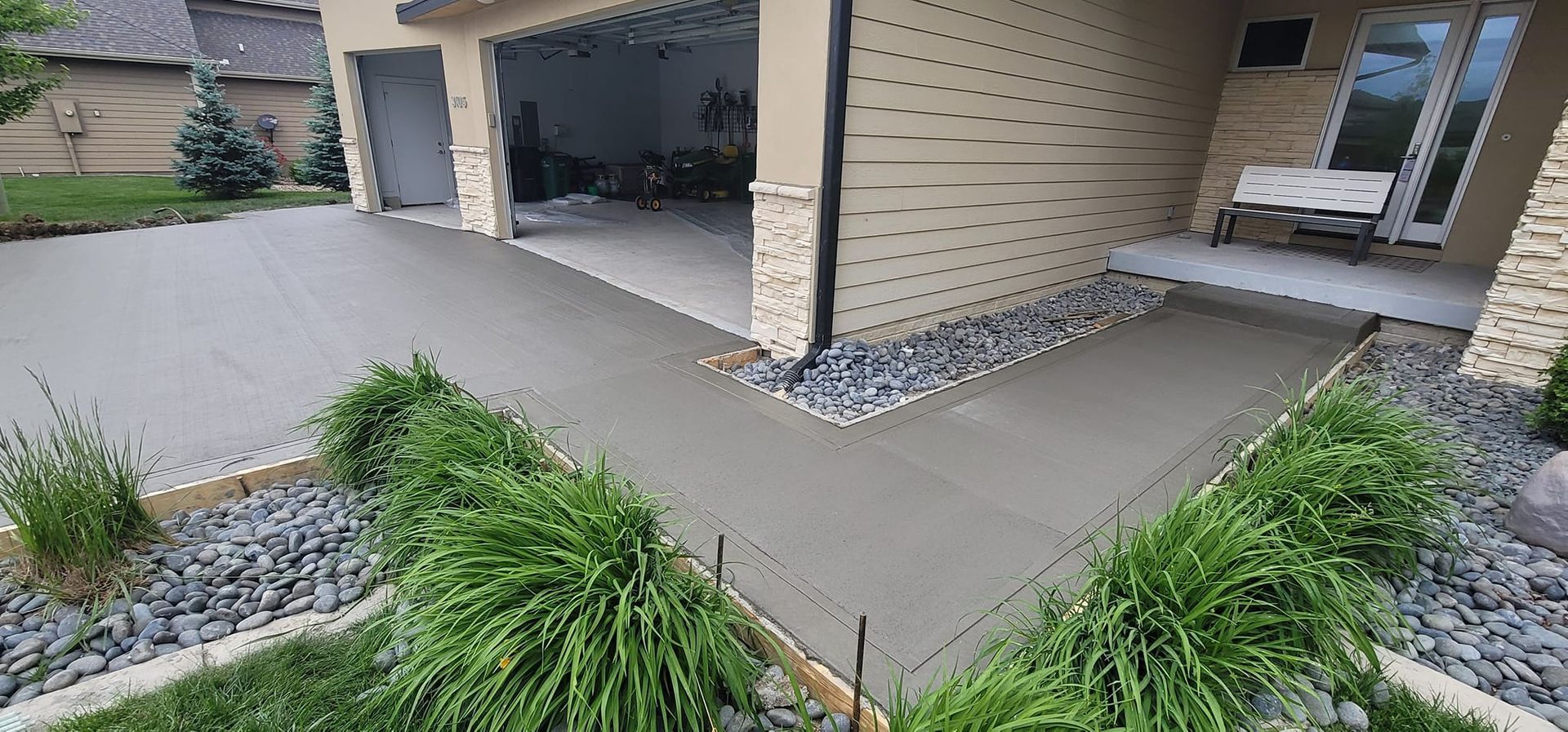 A concrete walkway is being built in front of a house.