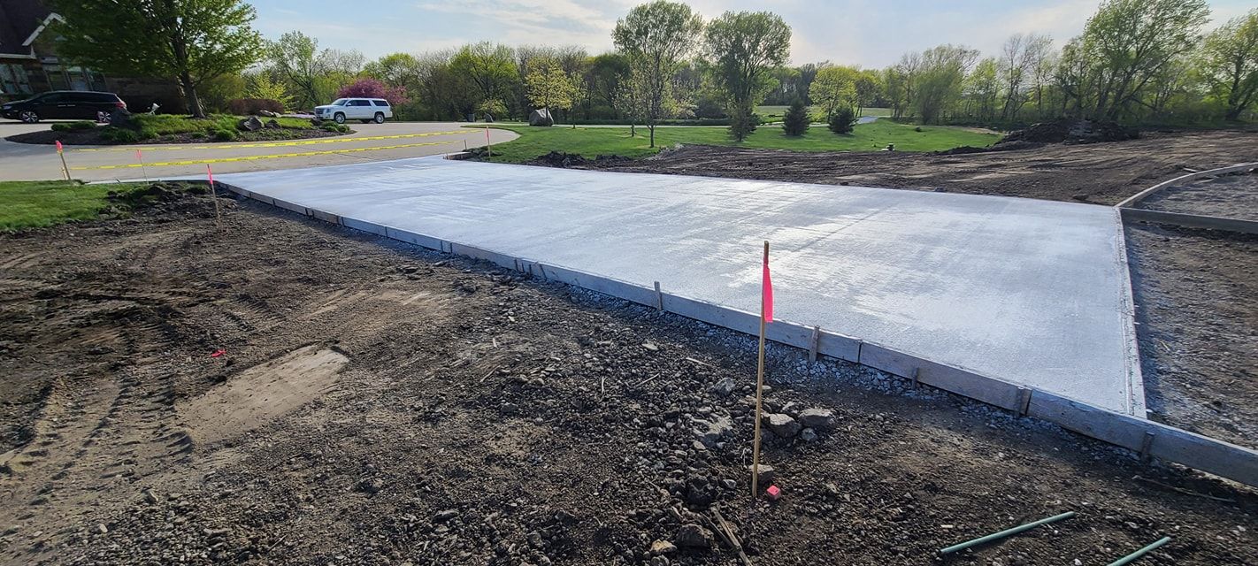 A concrete driveway is being built in the middle of a dirt field.