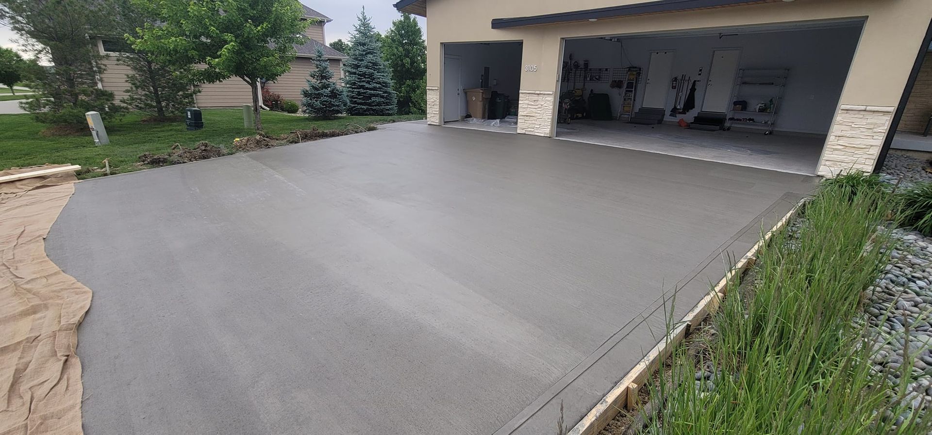 A concrete driveway is being built in front of a garage.