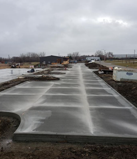 A concrete driveway is being built on a cloudy day.