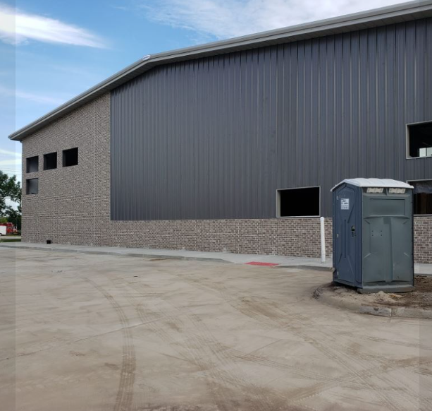 A large building with a portable toilet in front of it