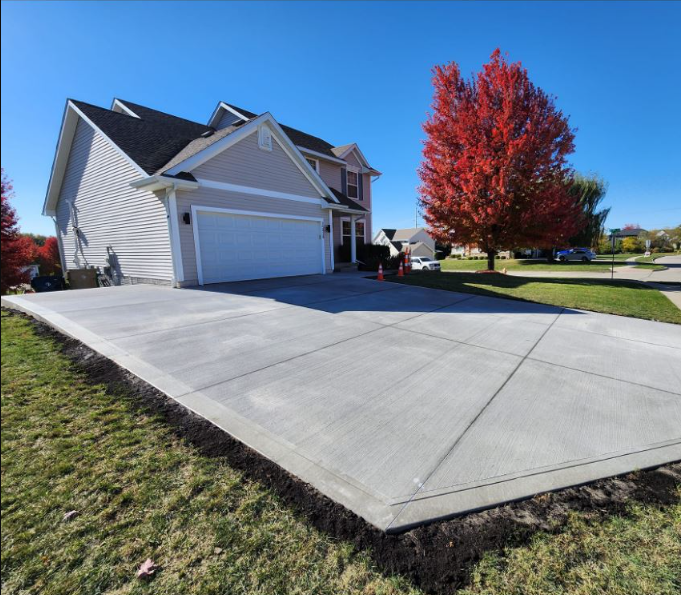 A house with a concrete driveway in front of it