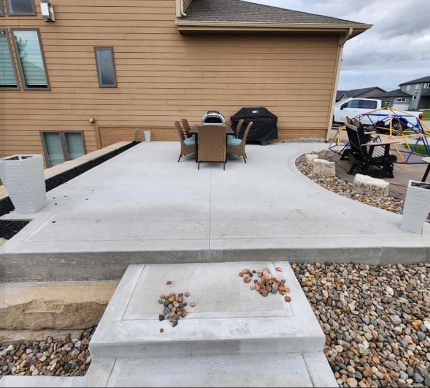 A patio with a table and chairs in front of a house