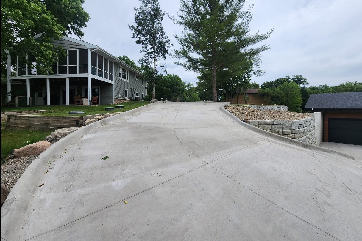 A concrete driveway leading to a house with a garage