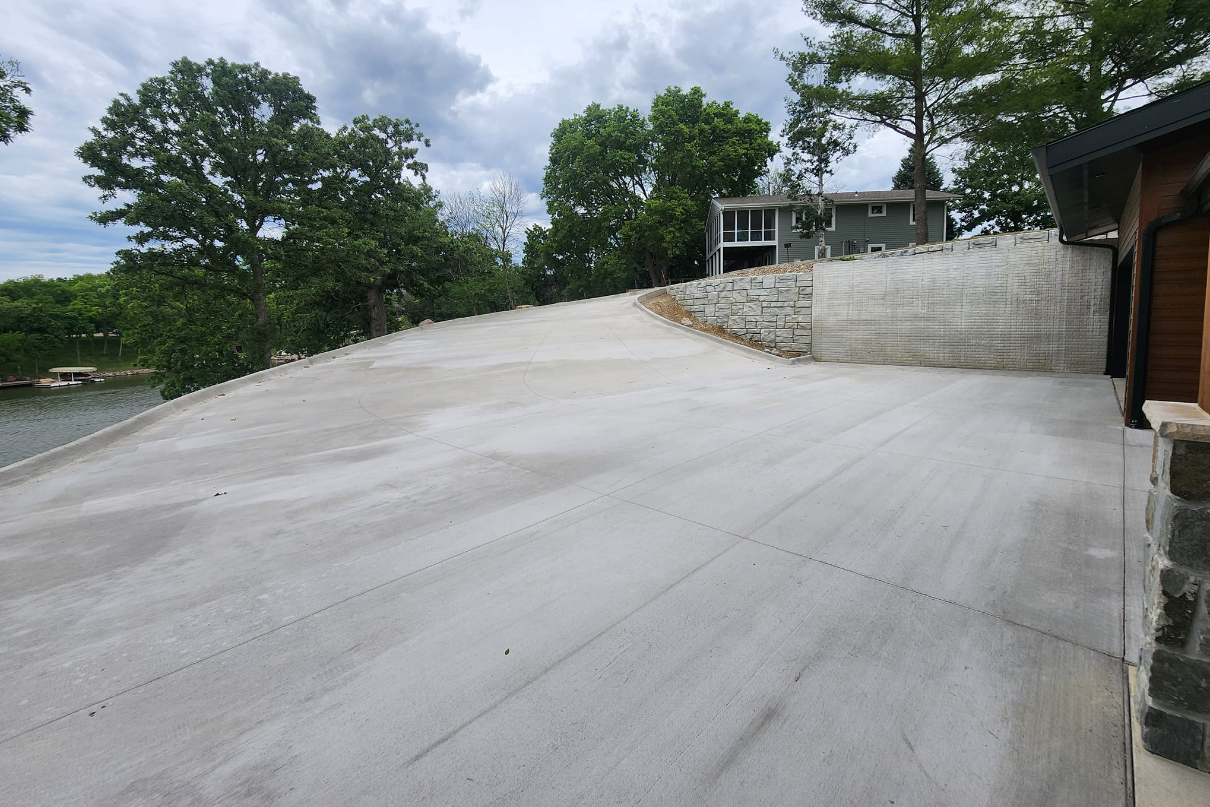 A large concrete driveway with a house in the background