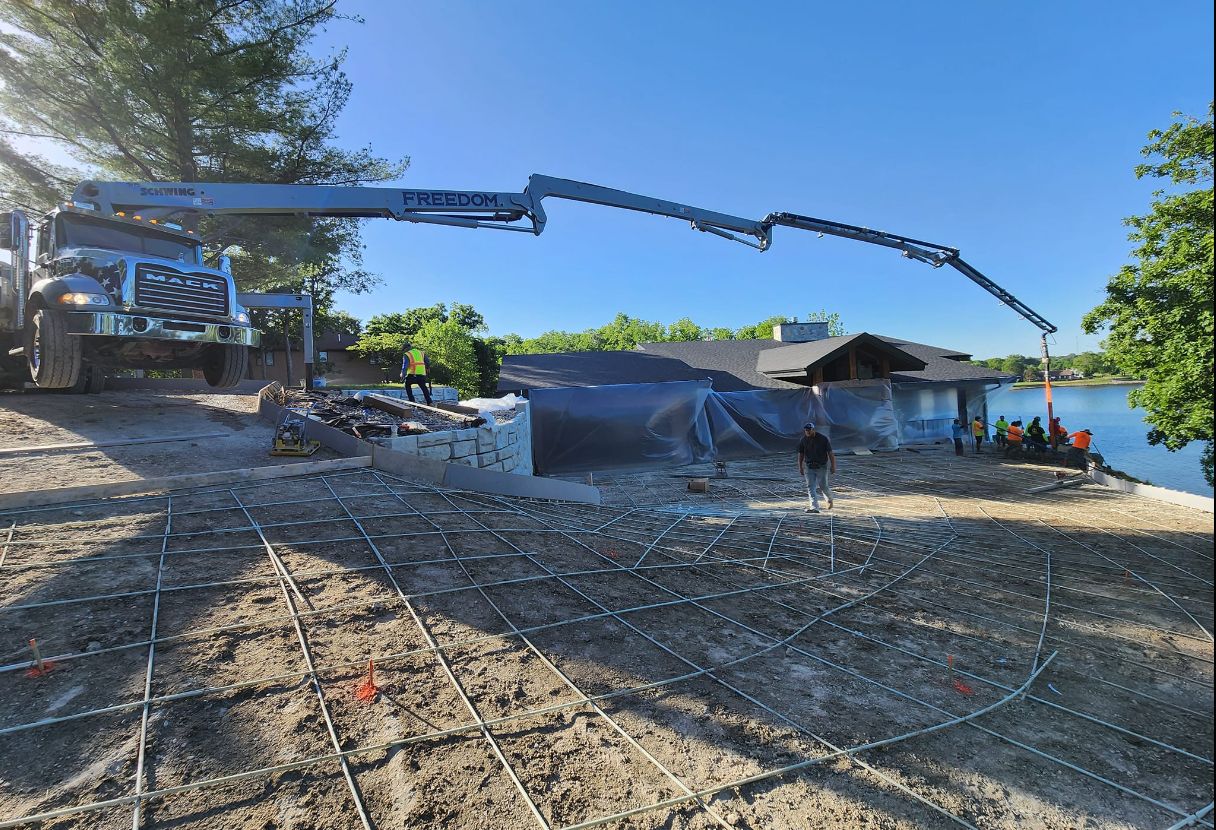 A crane is being used to pour concrete into a house