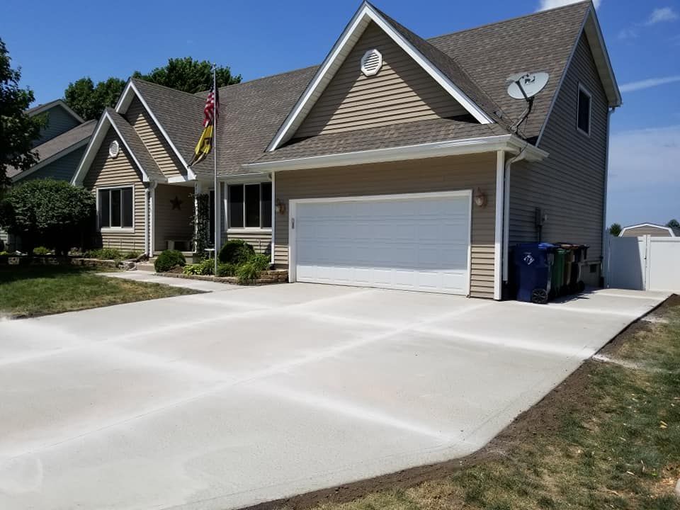 A large house with a concrete driveway in front of it.