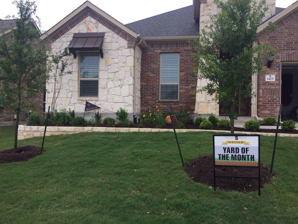 A yard of the month sign in front of a house