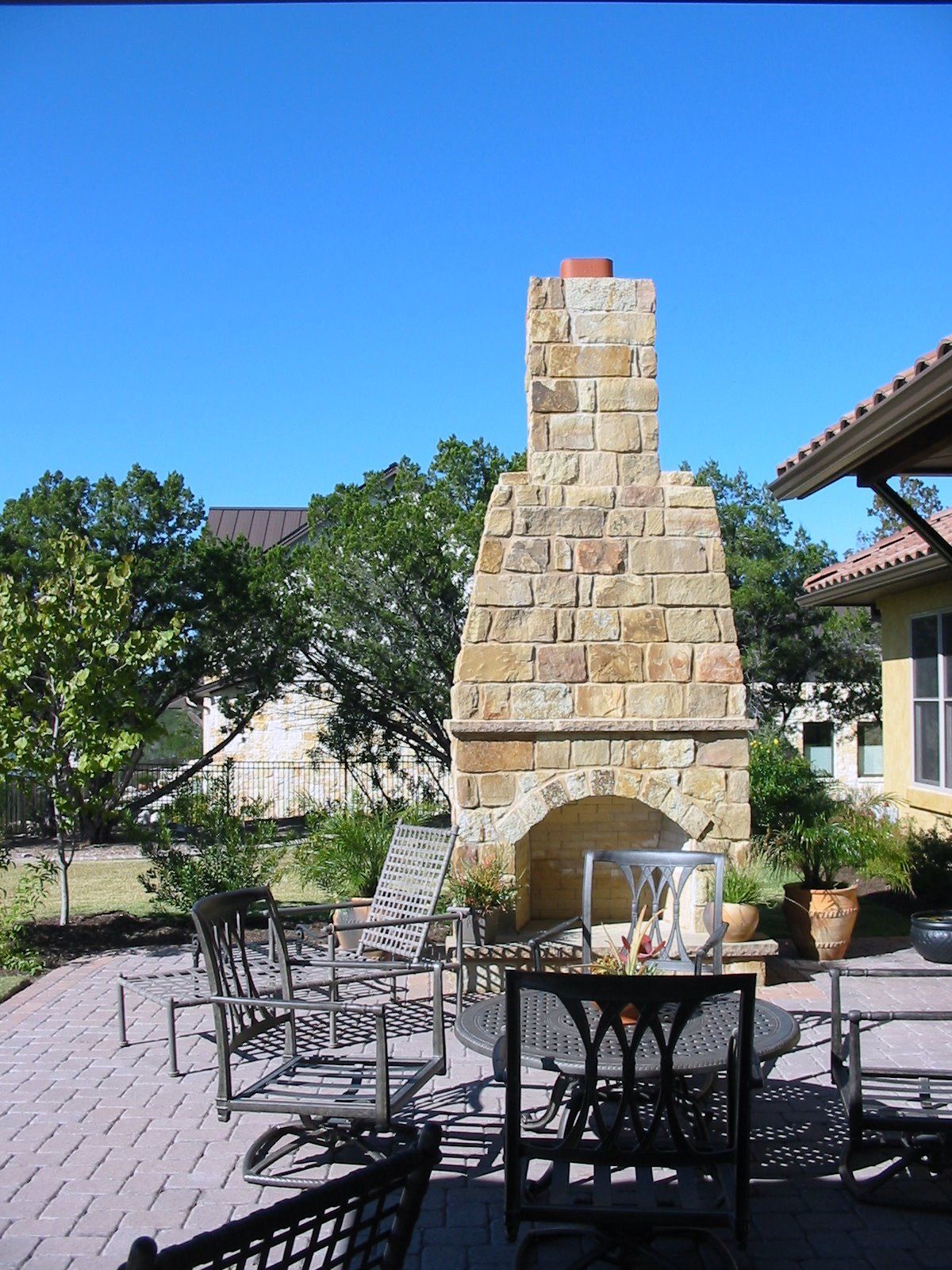 A large brick fireplace sits in the middle of a patio