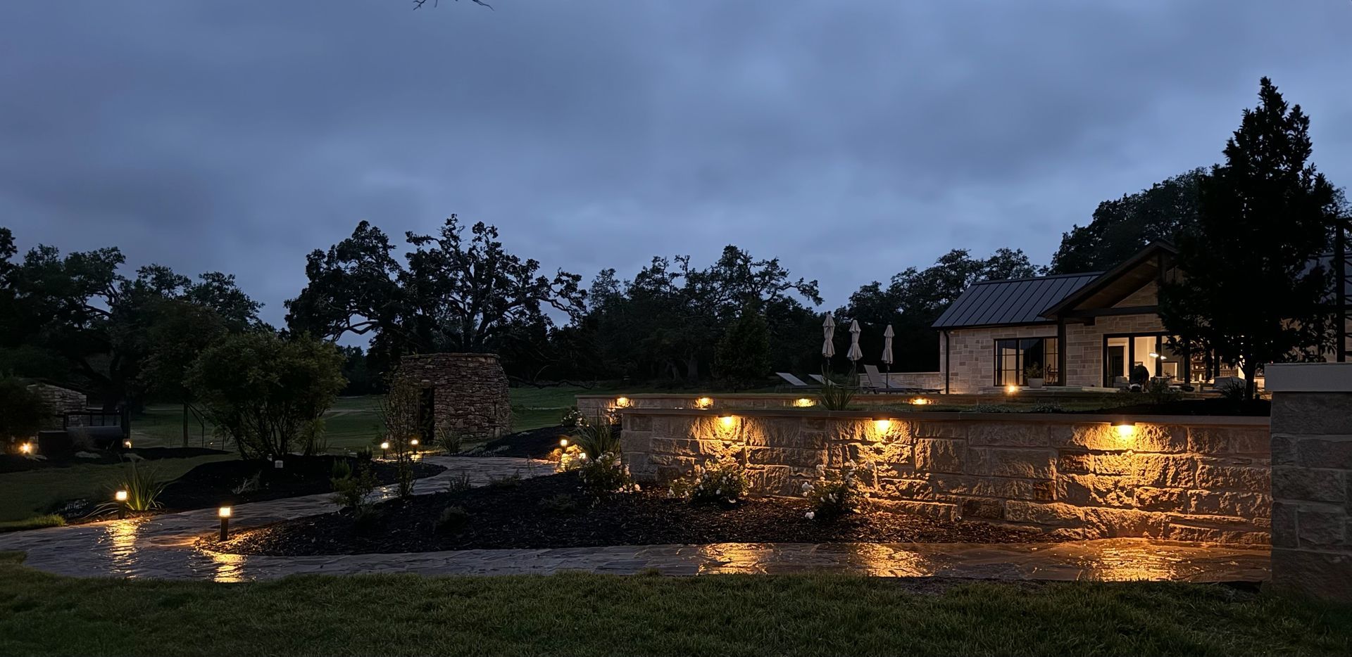 A house with a pond in front of it is lit up at night.