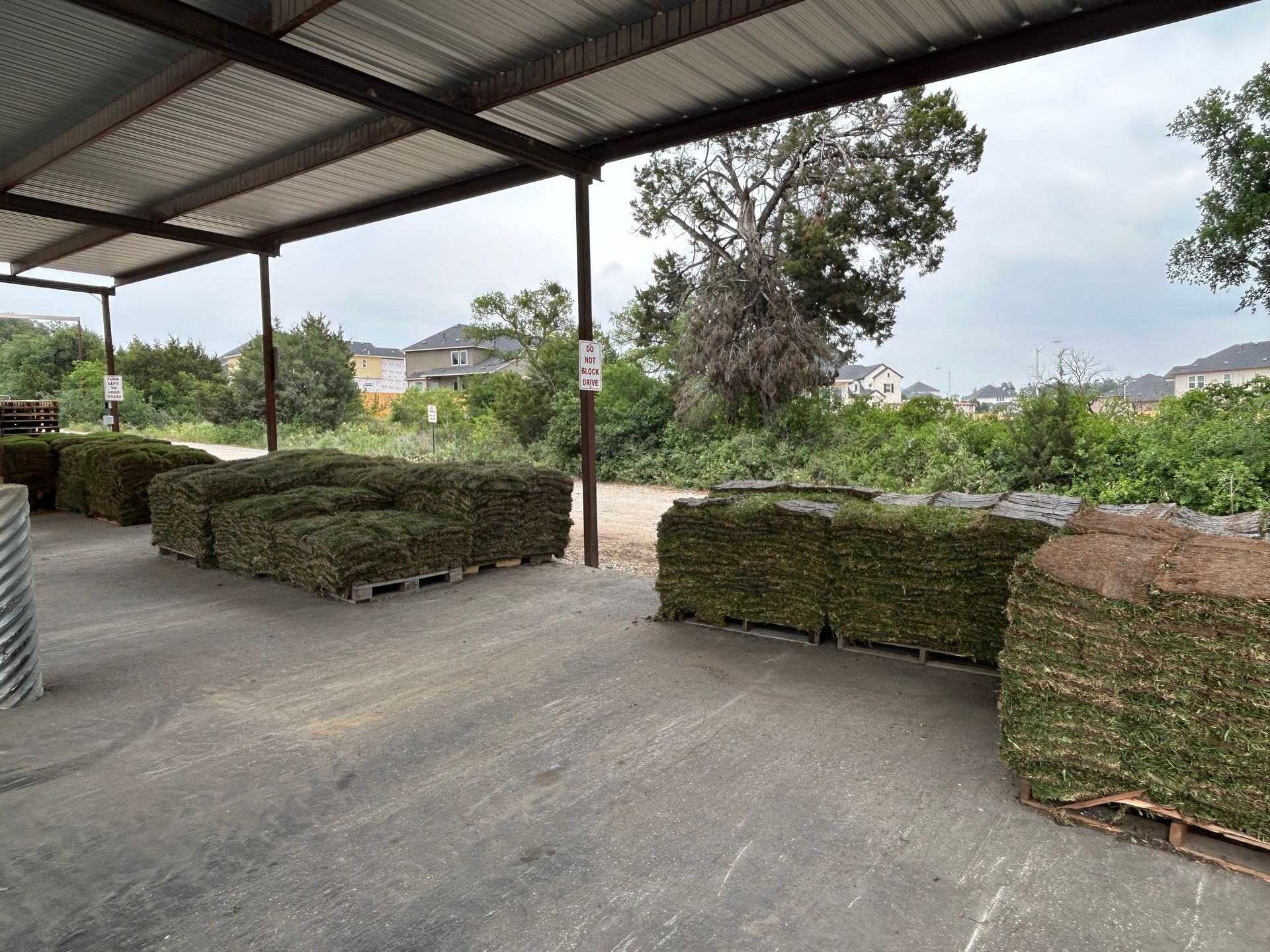 A bunch of hay bales are sitting under a roof