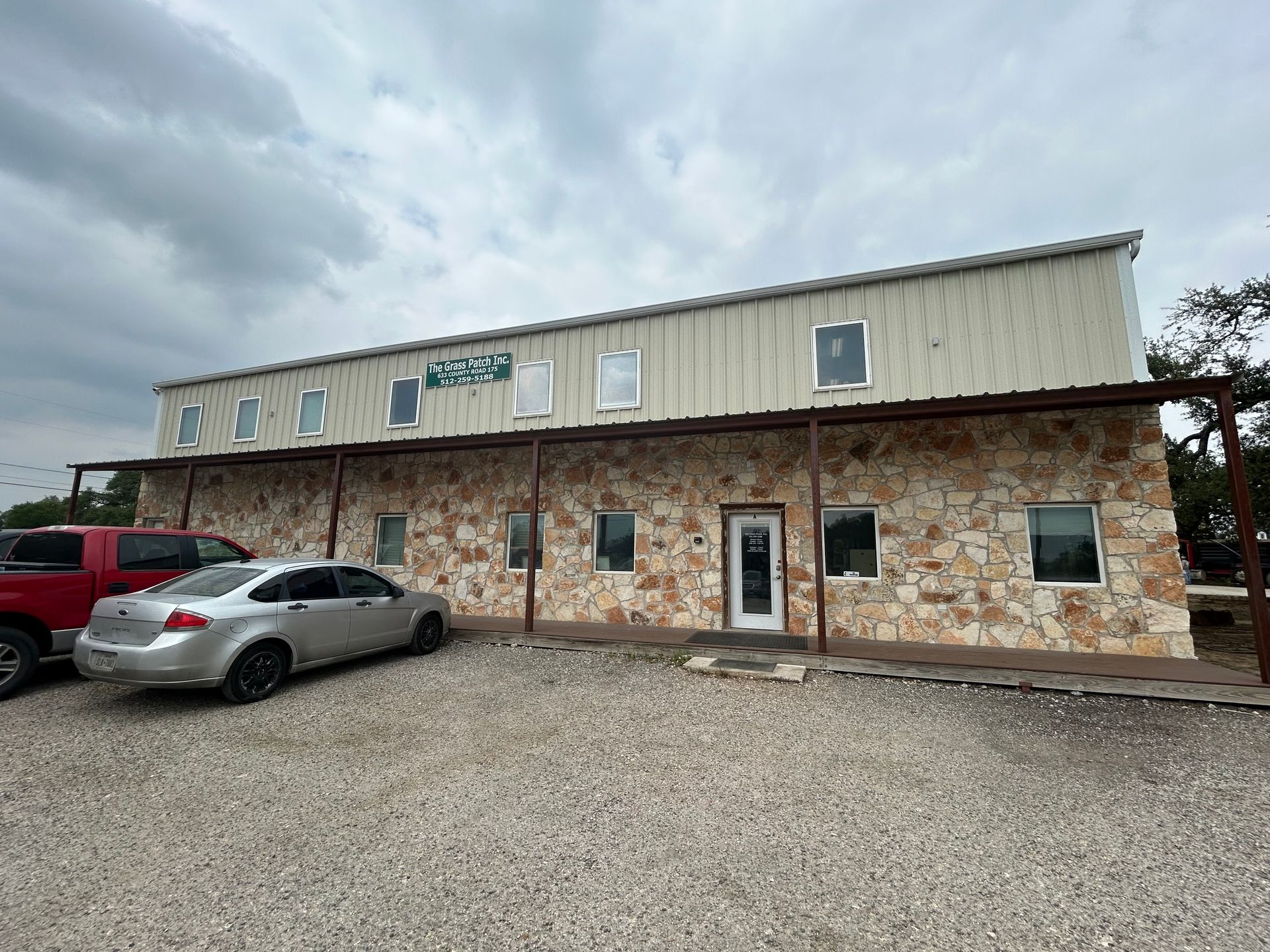A car is parked in front of a large building.