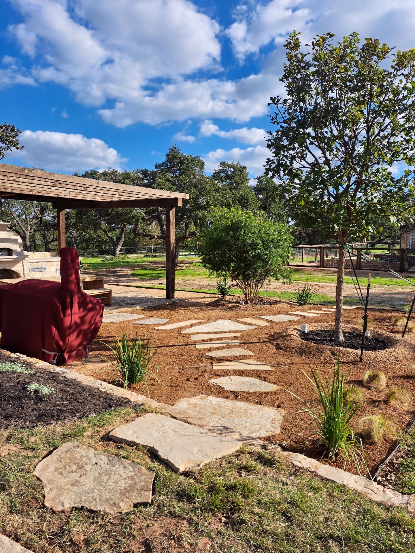 A stone walkway leading to a gazebo in the middle of a park.