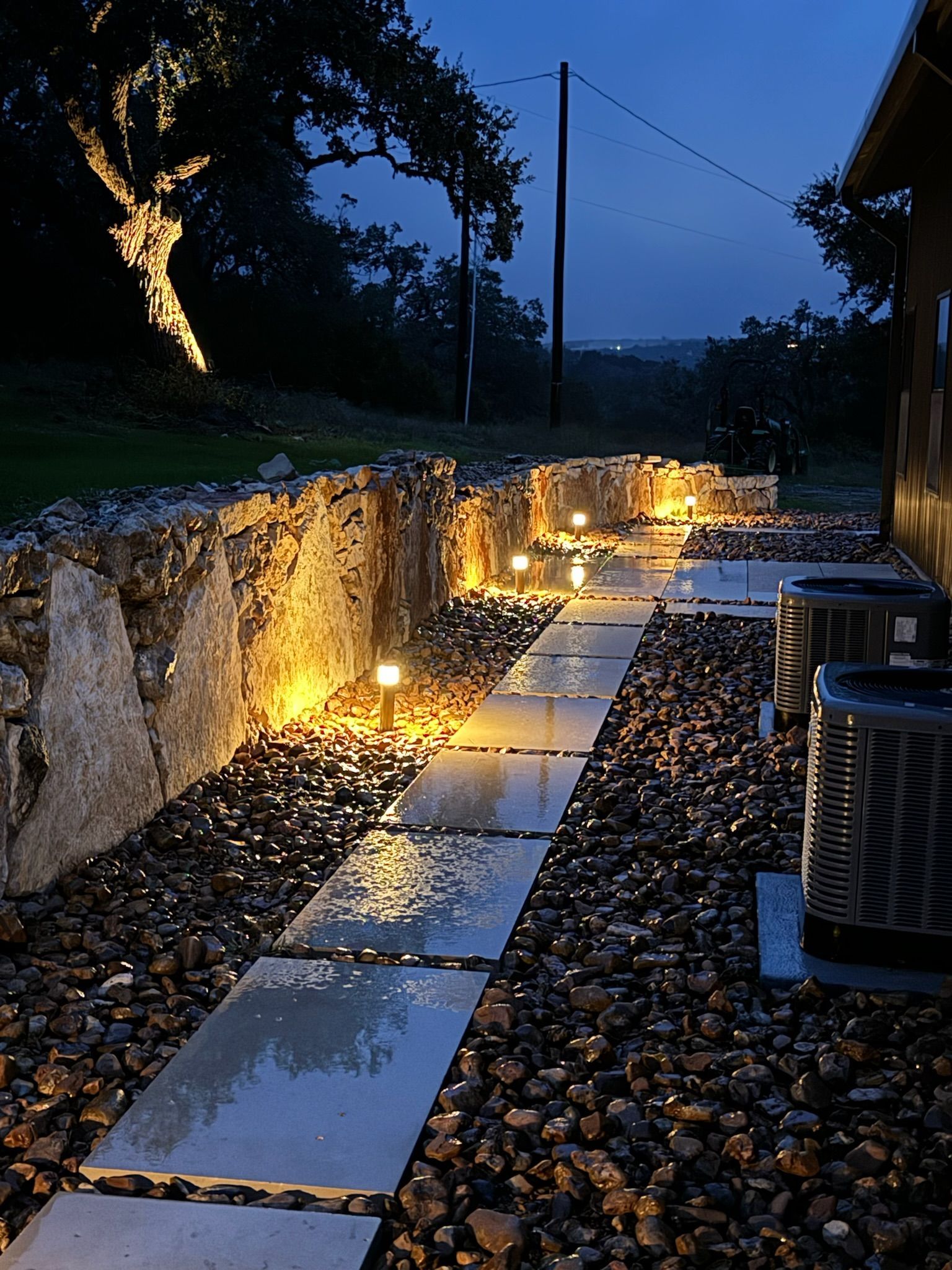 A stone walkway is lit up at night.